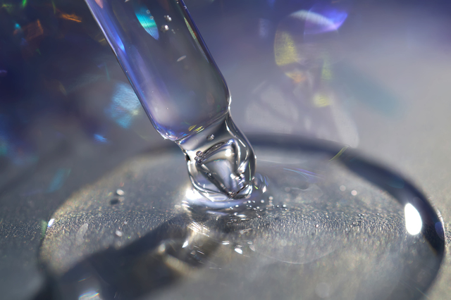 A pipette with a drop of serum in a Christmas theme .